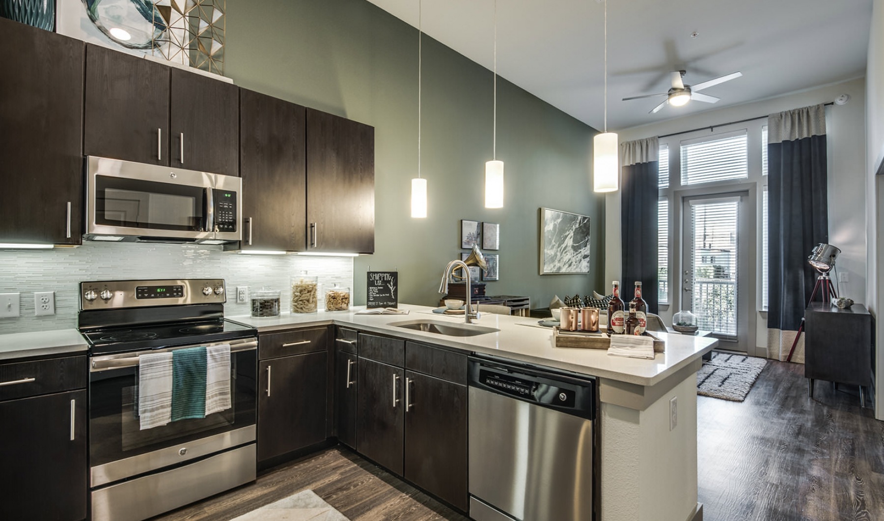 Model kitchen with stainless appliances and pendant lighting