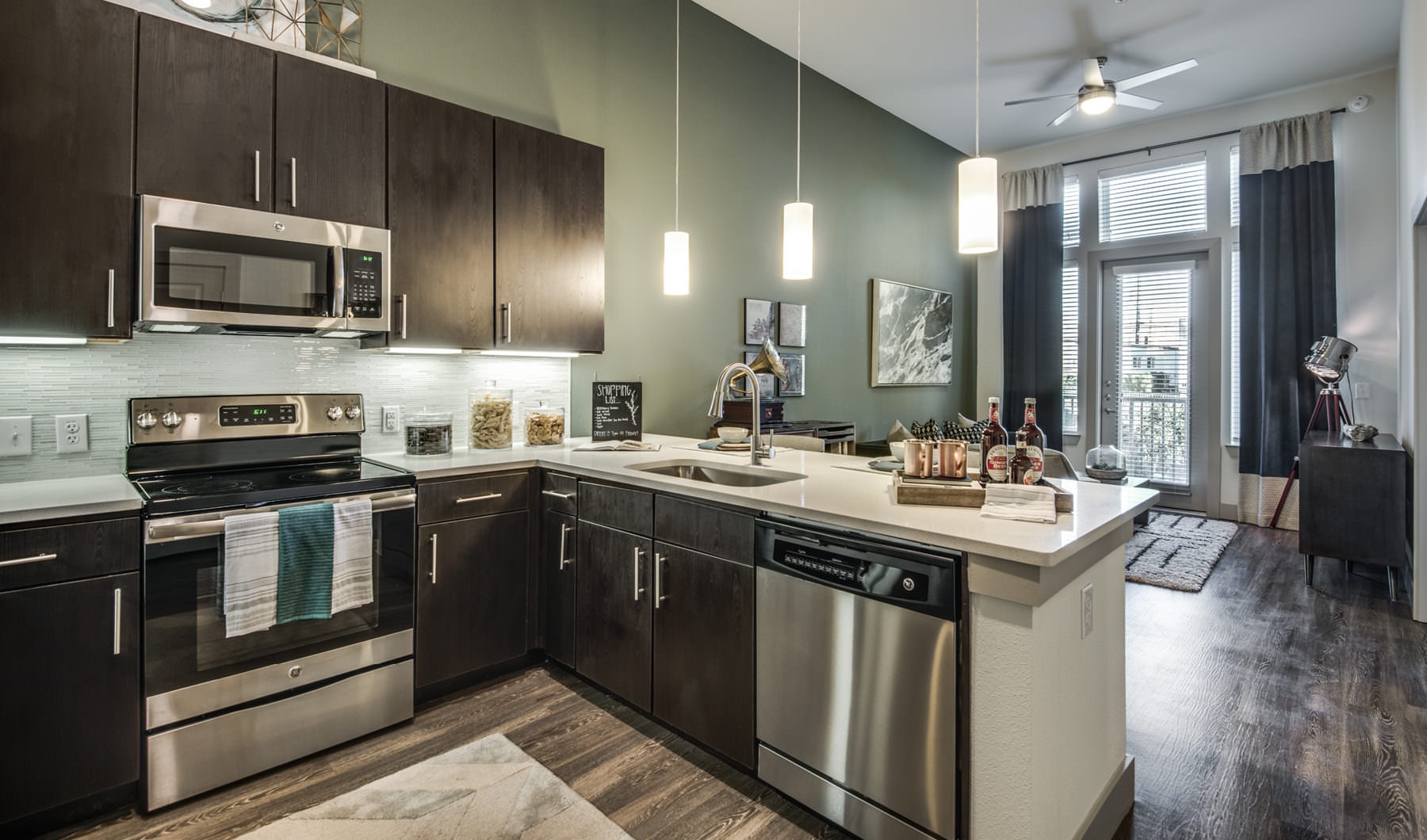 Model kitchen with stainless appliances and pendant lighting